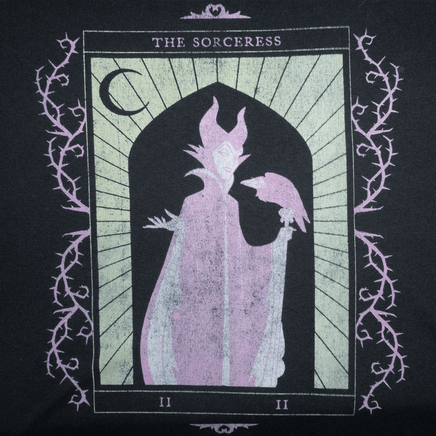 Illustration of a sorceress with a raven, featured on a black T-shirt design.