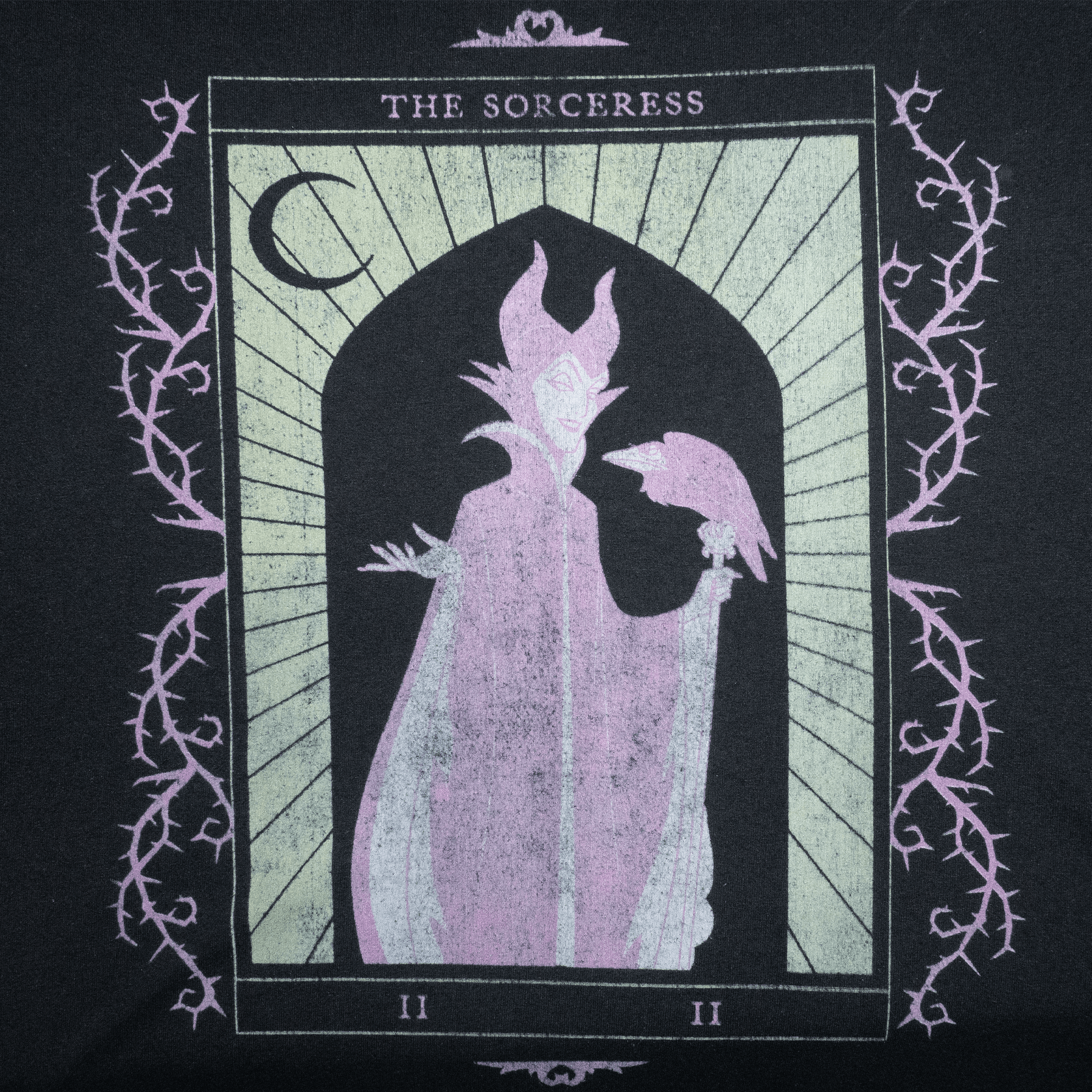 Illustration of a sorceress with a raven, featured on a black T-shirt design.