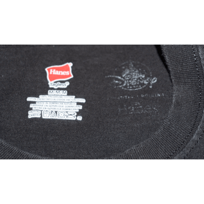 Hanes tag on a black Disney T-shirt, showing size M and care instructions, with a tagless design.