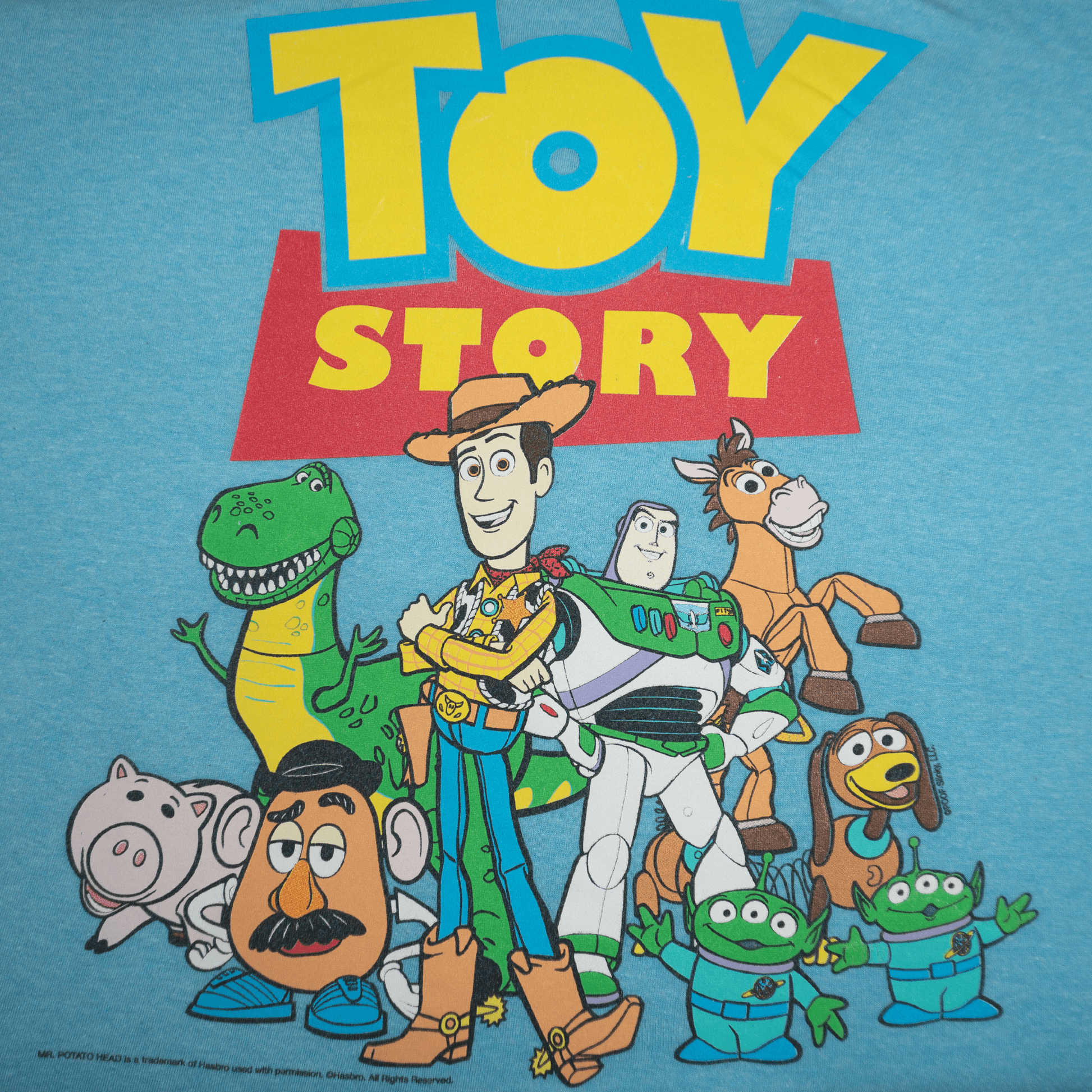 トイストーリーのキャラクターがプリントされた青いTシャツのデザイン